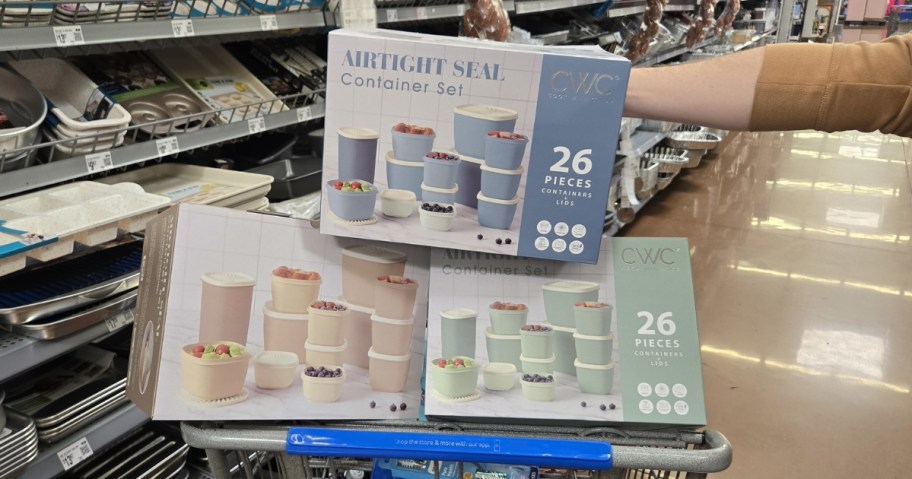 three boxes of Cook with Color 26-Piece Food Storage Sets in walmart shopping cart