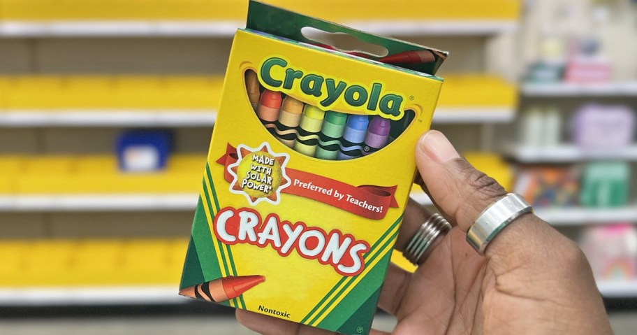 hand holding up a box of crayola crayons