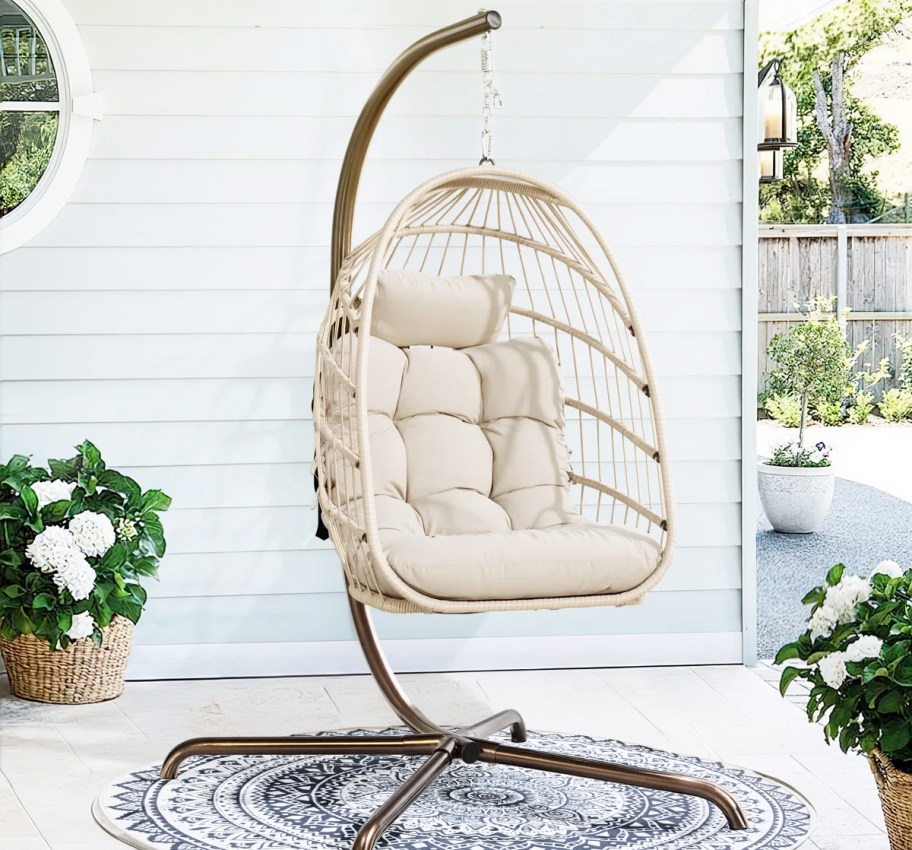 white swing egg chair with stand on a porch