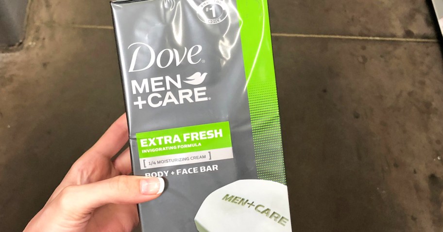 hand holding a grey and green box of Dove Men+Care Soap Bars in store