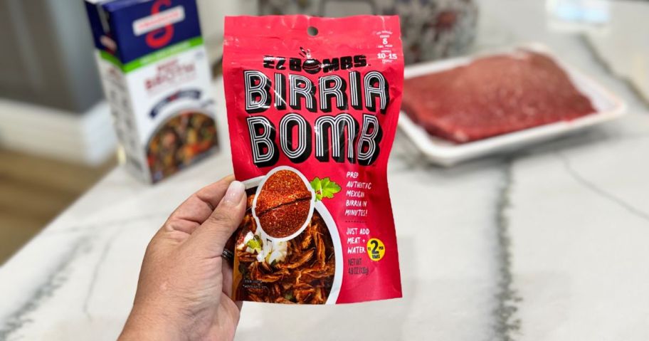 lina holding EZ Bombs Birria Bomb Seasoning 2-Pack bag in kitchen