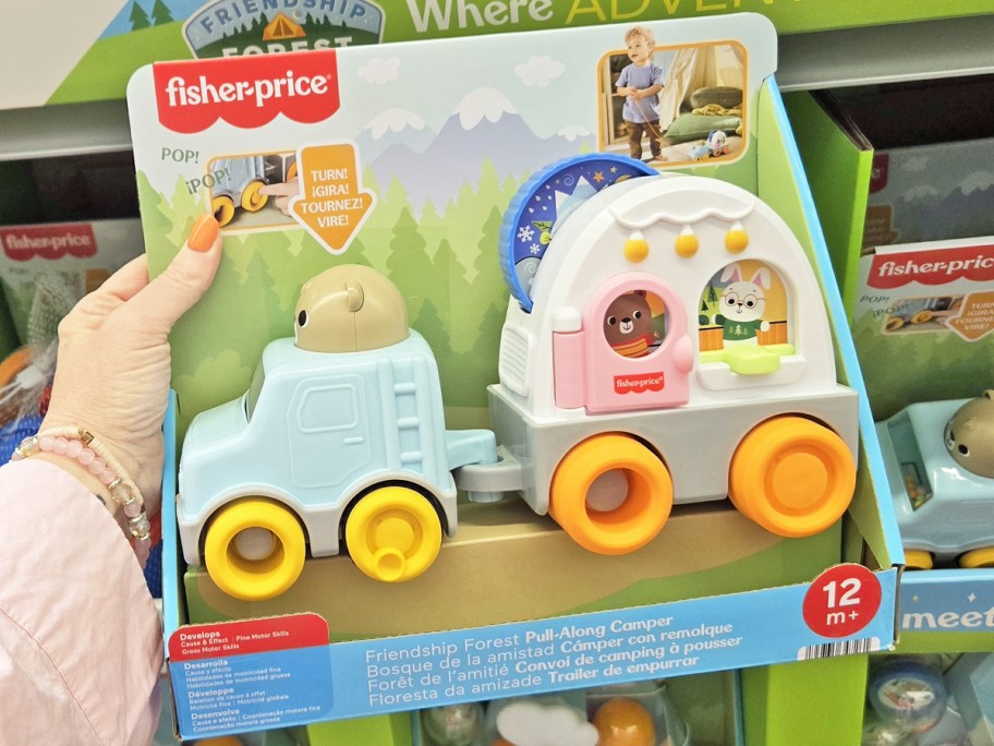 hand holding up Fisher-Price Friendship Forest Pull-Along Camper toy in store