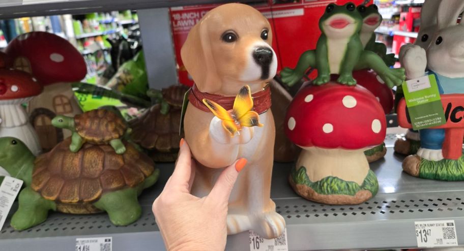 Hand holding dog statue with butterfly in hand