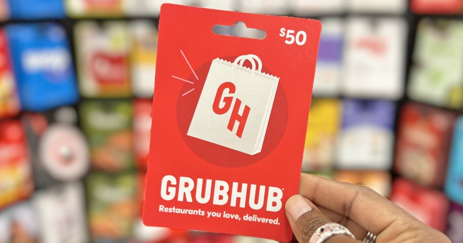hand holding up a red Grubhub gift card in store