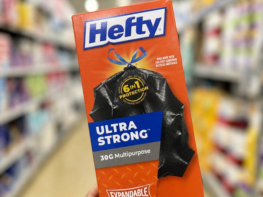 Hand holding a box of Hefty 30-Gallon Trash Bags in store
