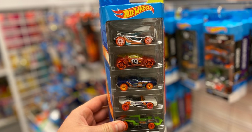 Hand holding up hot wheels, multi pack