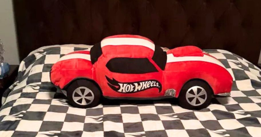 pillowfort Hot Wheels Classic Light-Up Car Kids' Novelty Cuddle Plush Pillow in Red on bed