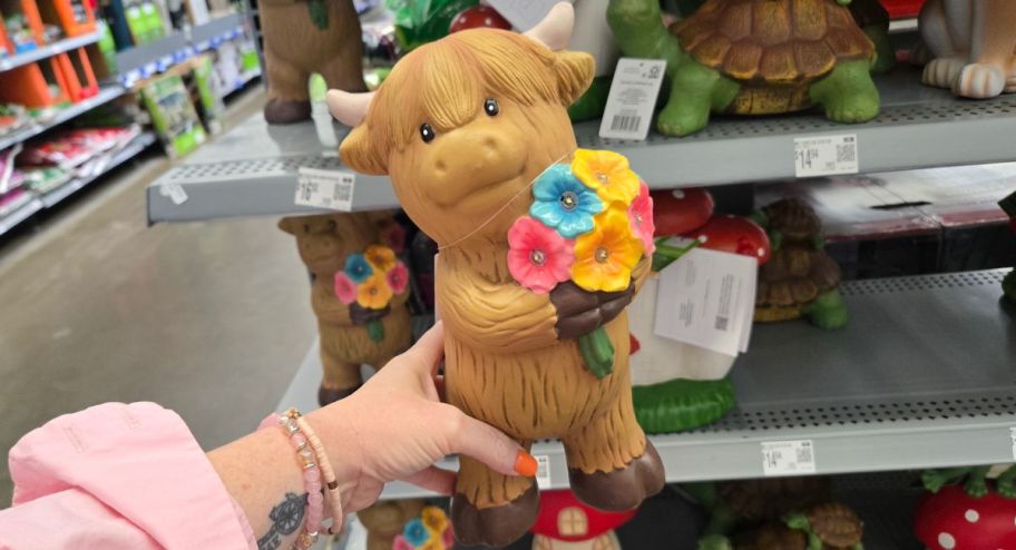 hand holding hyland cow statue at the store