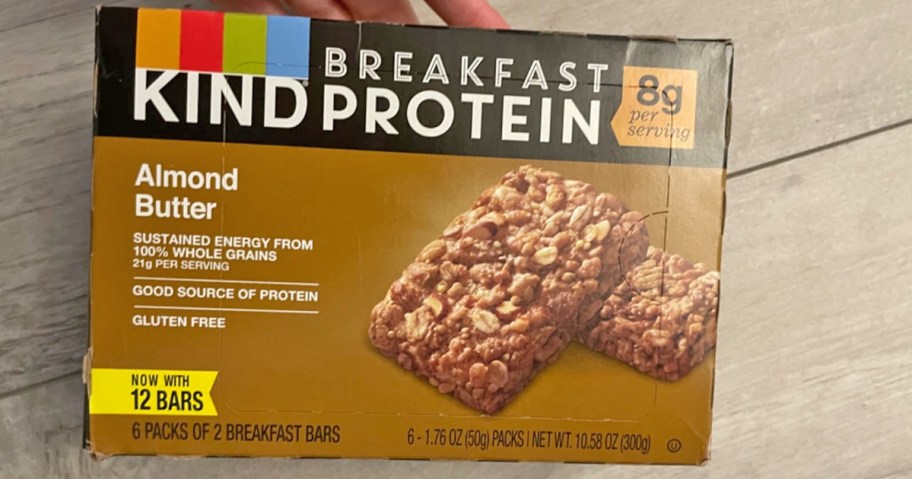 hand holding a box of KIND Breakfast Protein Bars