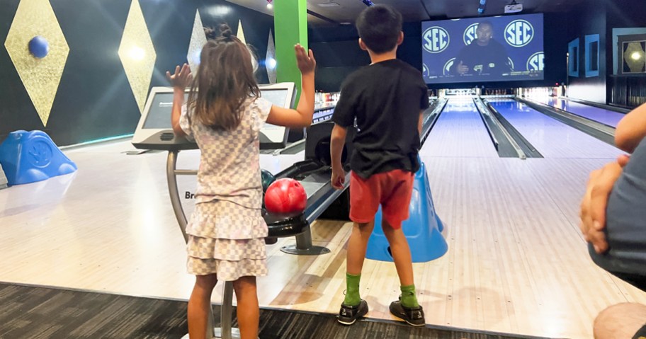 kids standing on bowling lane