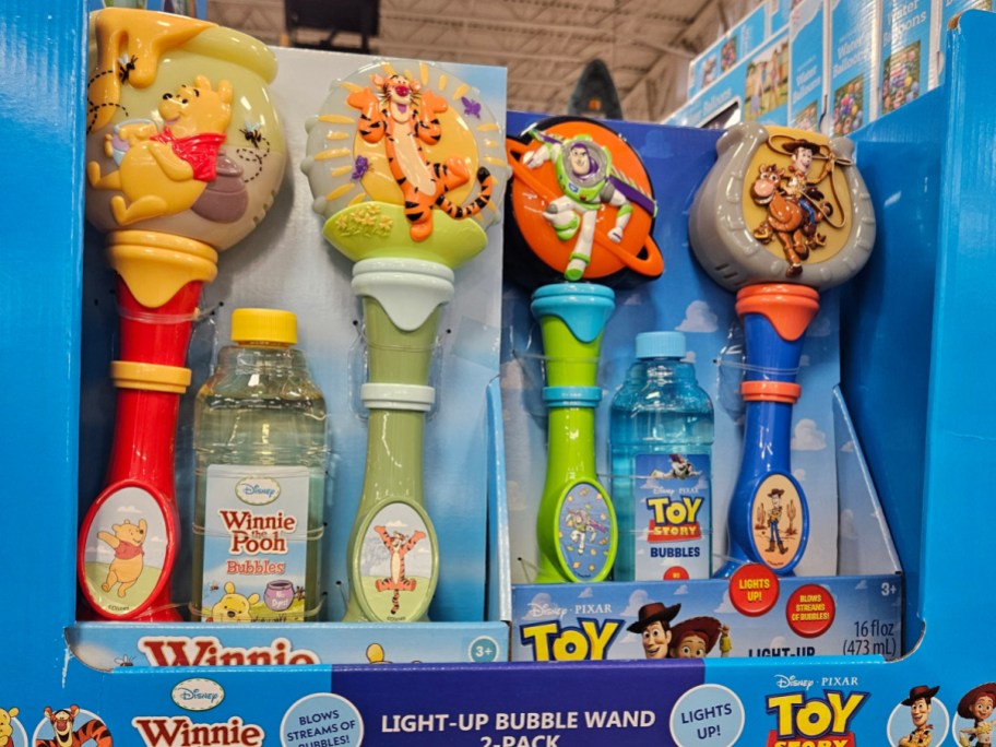 A display of bubble wands featuring characters from Disney's Winnie the Pooh and Toy Story, with colorful handles and bubble solution bottles.