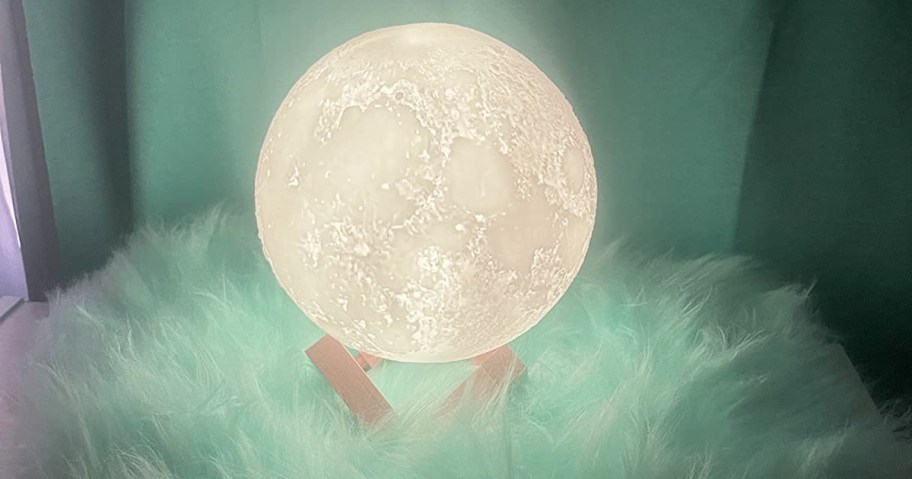 round moon lamp on a fluffy green throw