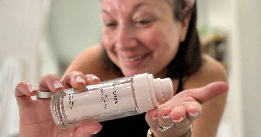 Woman using her self tanner on her hands