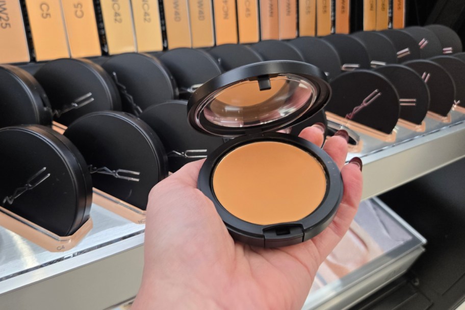 hand holding opened powder compact