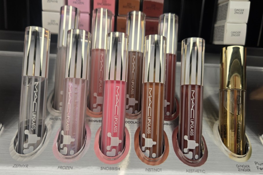 five lip glosses with chrome caps on shelf