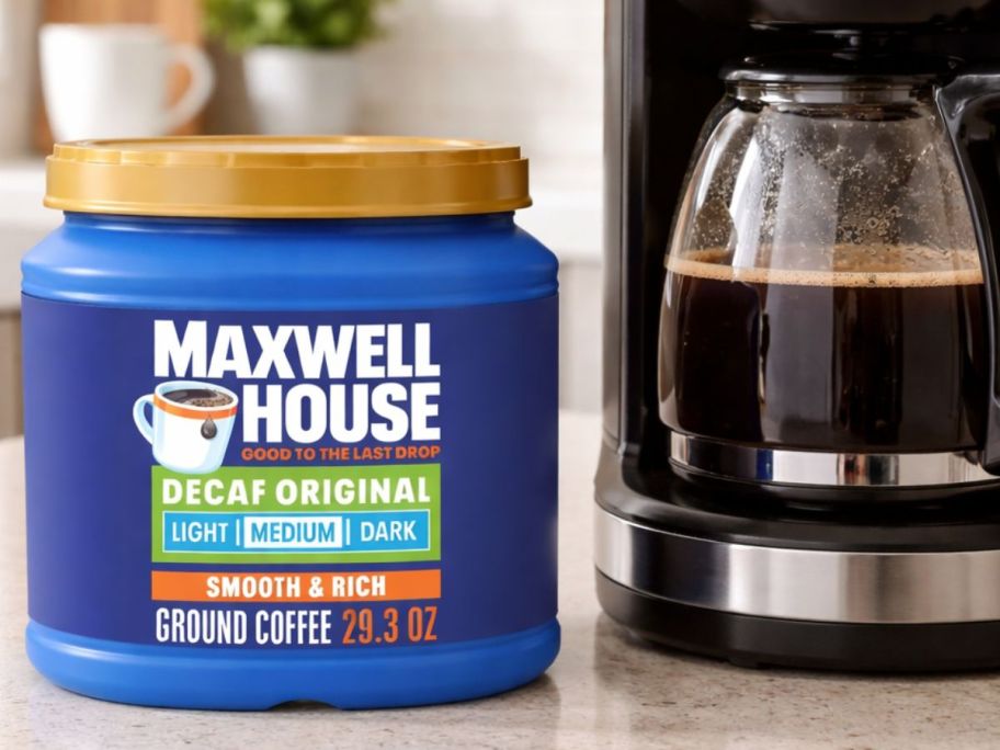 Maxwell house coffee on top of the table with coffee pot next to it 