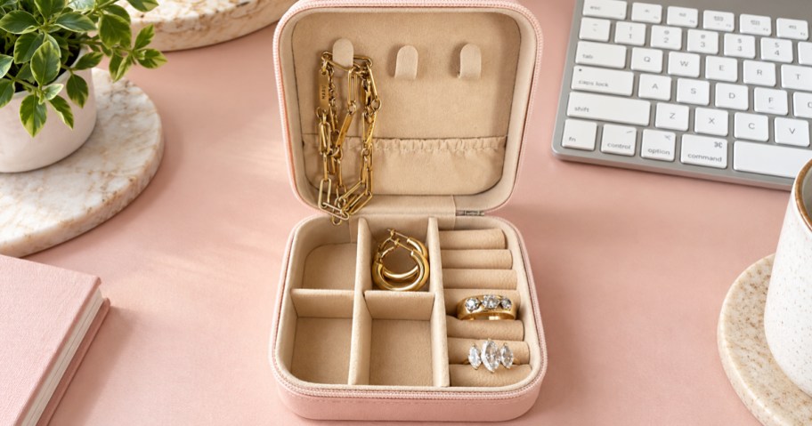 opened pink jewelry case with bracelets and rings inside