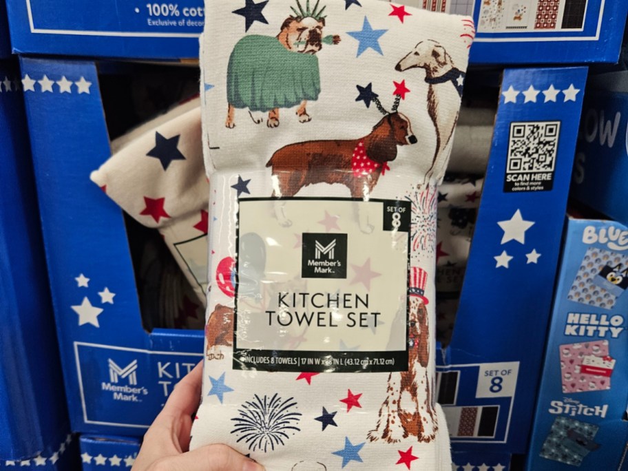 Kitchen towel set featuring various dog illustrations and patterns, displayed in a store.