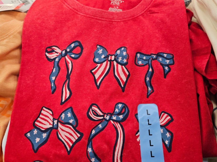 A red shirt with a pattern of bows, some featuring stars and stripes.