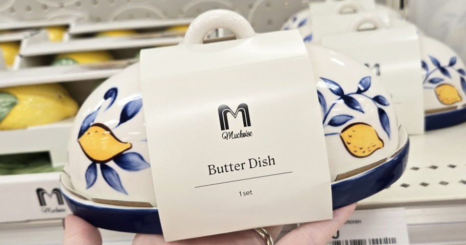 hand holding up a lemon print butter dish