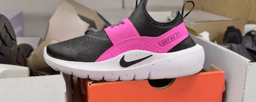 black and pink nike sneaker on top of shoe box in store