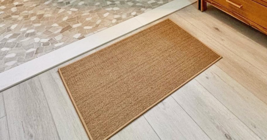 tan woven bath mat in a bathroom