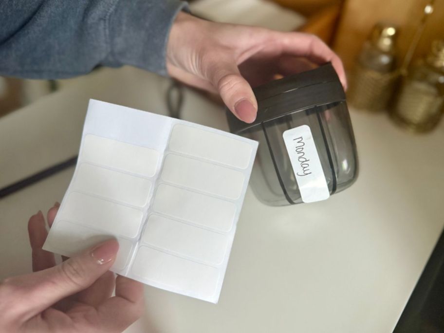 hand holding PULIV Portable Pill Dispenser Bottle labels