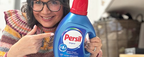 woman holding up and pointing to a bottle of persil laundry detergent