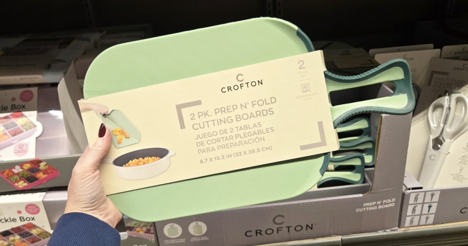 hand holding up a green set of cutting boards