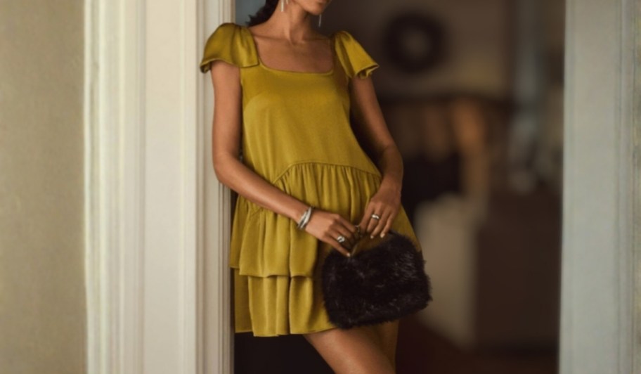 woman wearing Scoop Women's Satin Bow Mini Dress leaning on door frame holding clutch