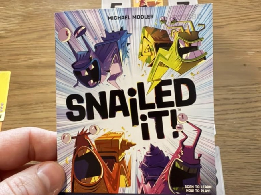 hand holding box to Snailed it! Card Game