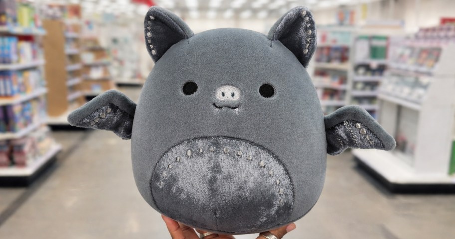 hand holding up a bat squishmallows plush in store