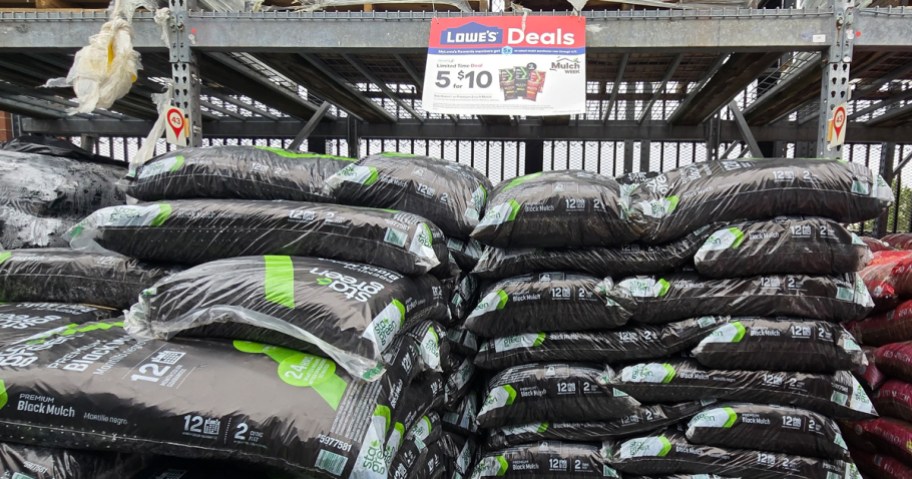 stacks of black bags of mulch in garden center
