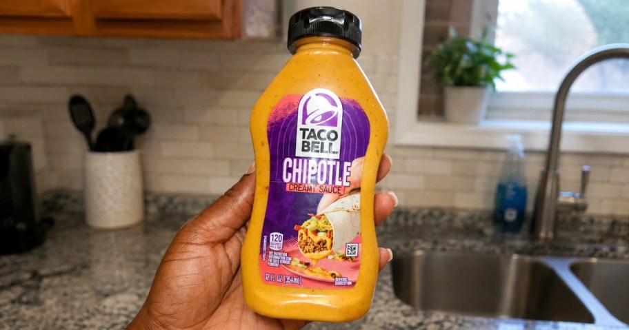 hand holding a bottle of Taco Bell Chipotle sauce