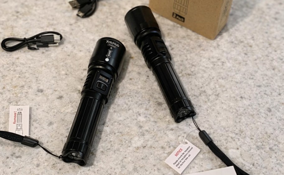 two black flashlights on a counter