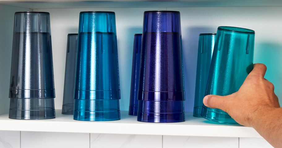 hand reaching for blue cups on a shelf