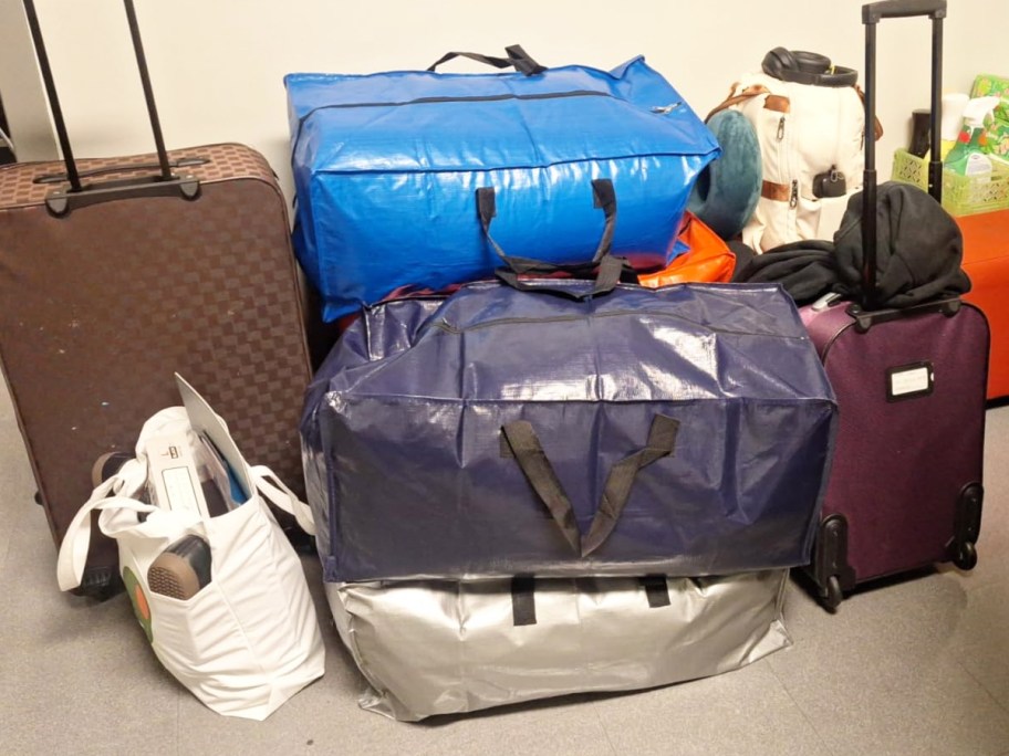 large moving bags stacked near suitcases