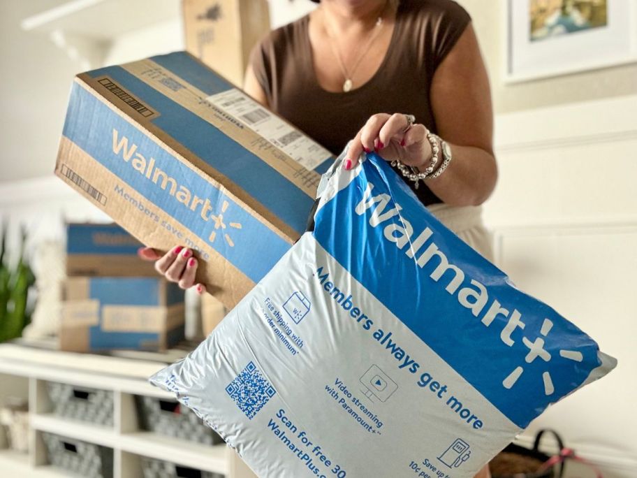 Woman holding a delivery box and bag from Walmart