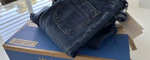 A folded pair of jeans on top of a walmart box.