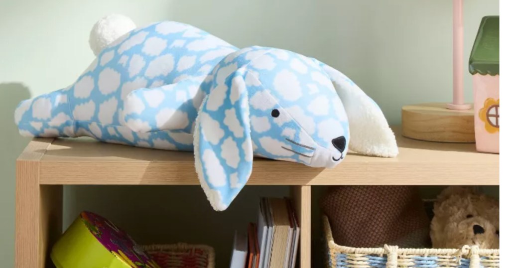 Large bunny, plush with cloud themed pattern on bookshelf