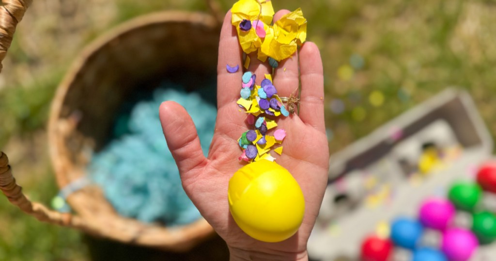 Hand holding up crunched, yellow confetti, Easter egg