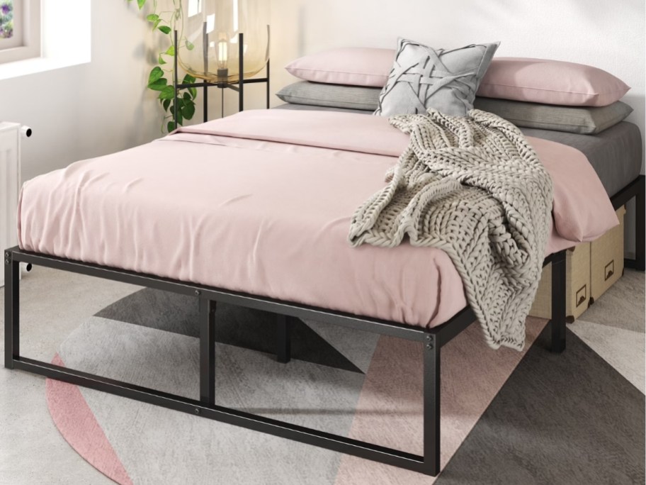 a queen metal platform bed with coverlet and throw pillows