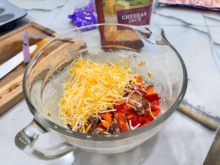 adding cheese and bacon to breakfast muffins 