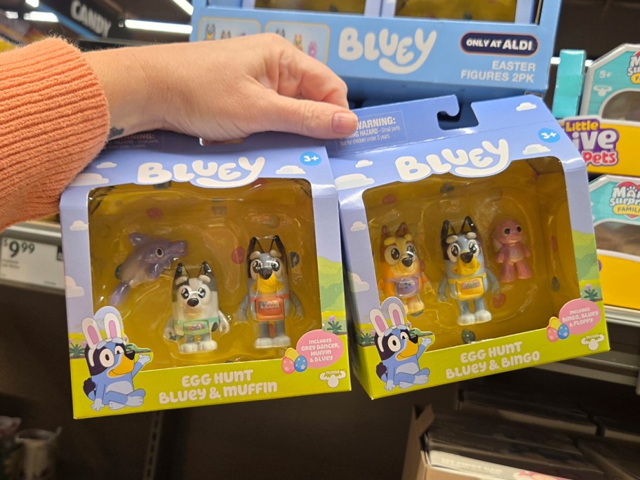 Two different bluey toys in persons hand 