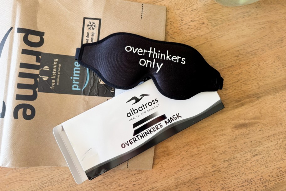 black sleep mask with 'overthinkers only' on it