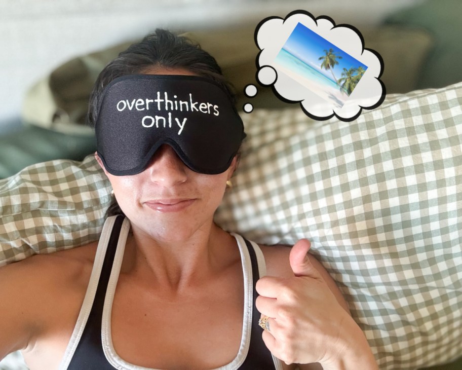 woman with black sleep mask dreaming of island vacation