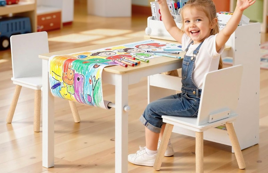 child sitting at art table with supplies