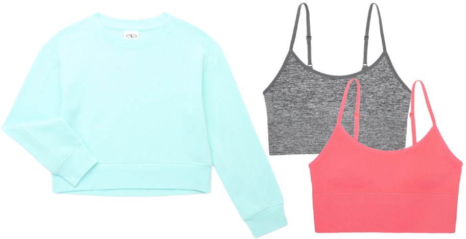 Three tops: a light blue long-sleeve sweatshirt with a crew neck, a gray sleeveless crop top with thin straps, and a coral sleeveless crop top.