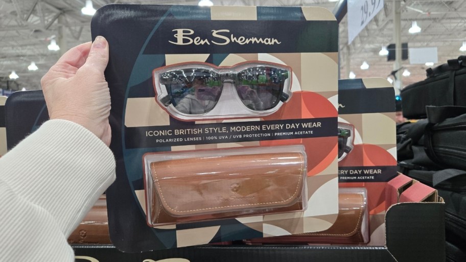 womans hand holding a pair of sunglasses packaged with a case