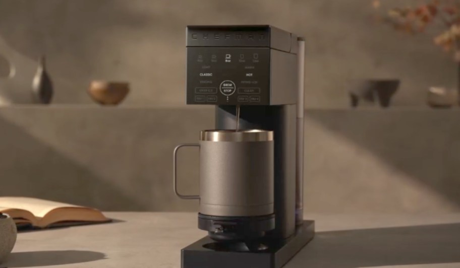 Chefman Coffee Maker on a counter with a cup in it brewing coffee.